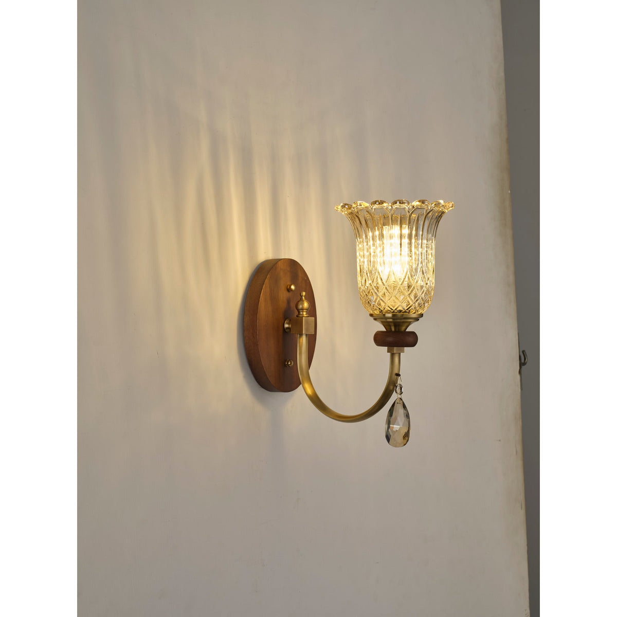 Supplier real three-quarter product photograph of the ribbed tulip glass wall sconce illuminated